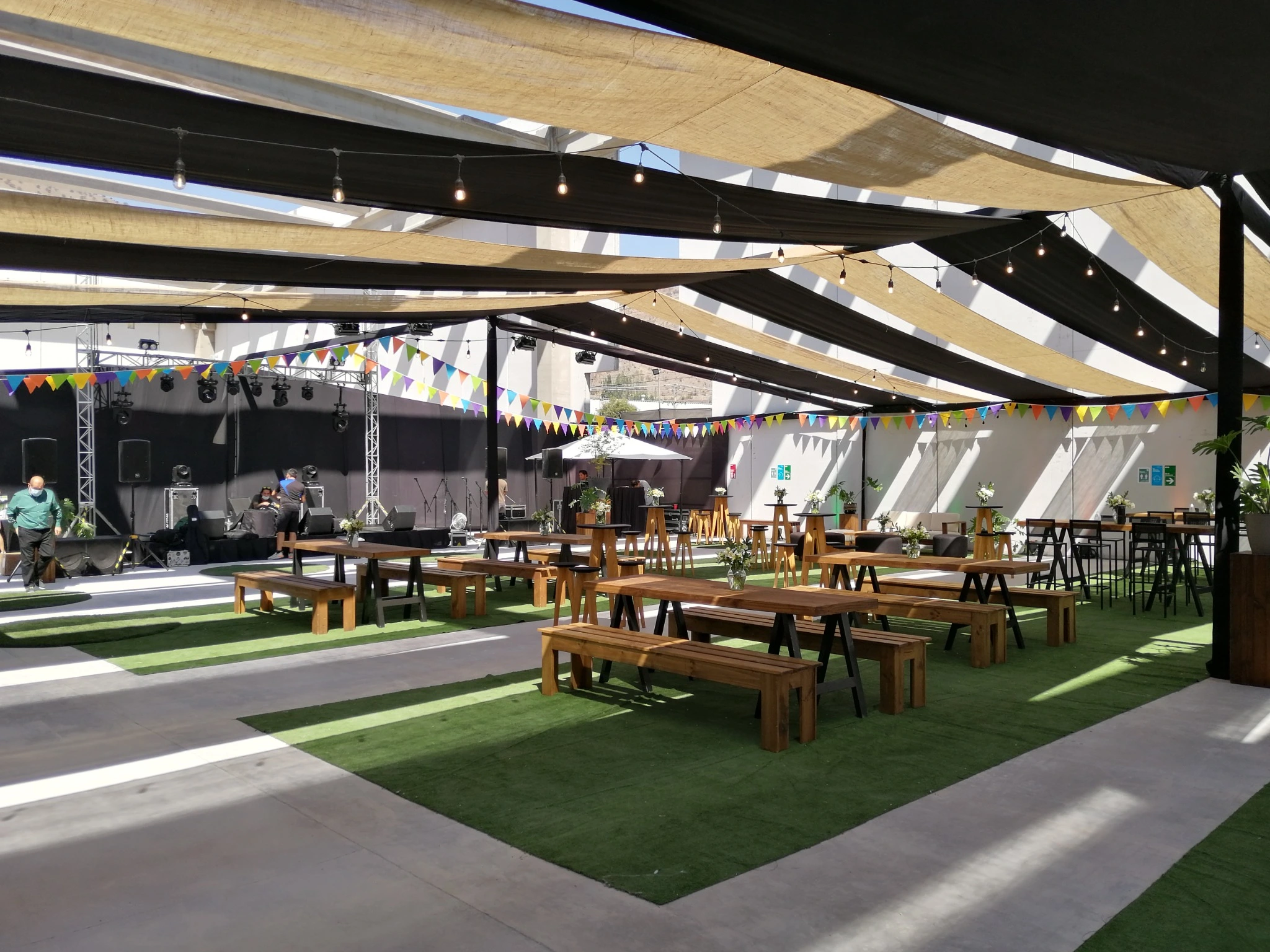Espacio de evento con mobiliario, escenario y cubierta